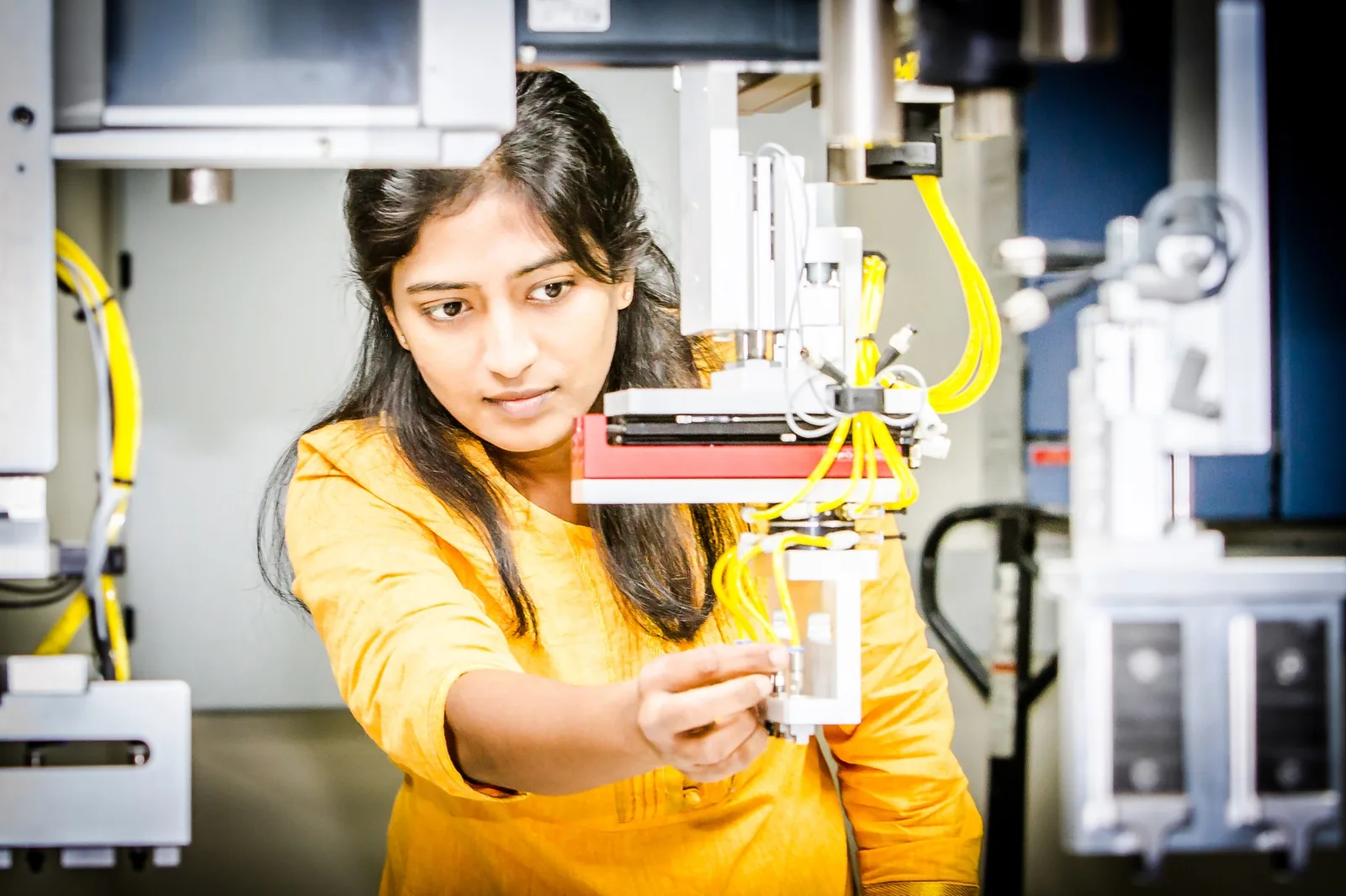 Woman expertly adjusting complex equipment for web development the region.