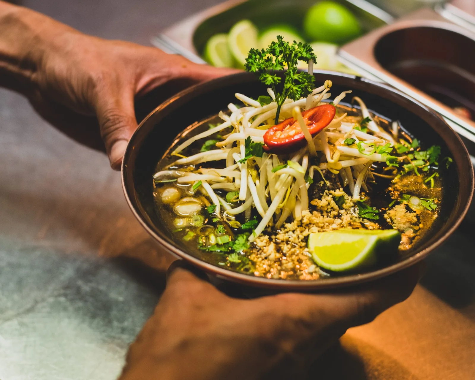 Hands holding a vibrant gourmet noodle bowl by Vancouver Website Design the region.