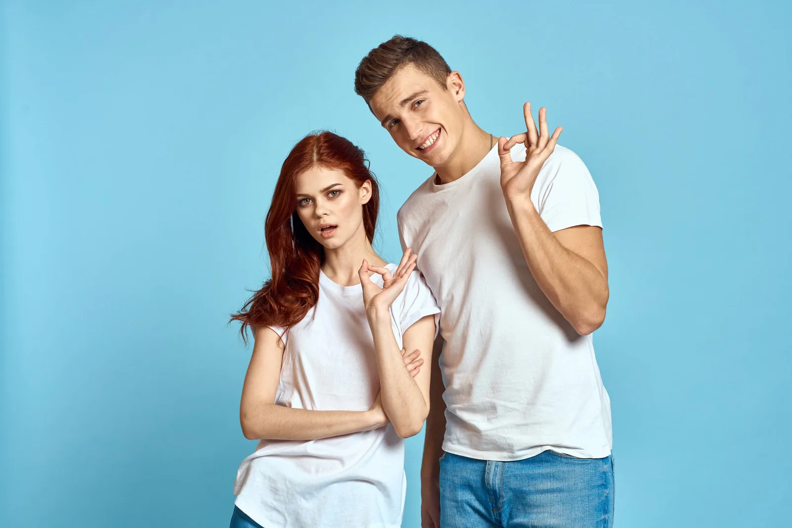 Man and woman giving 'okay' signs, for quality website design.